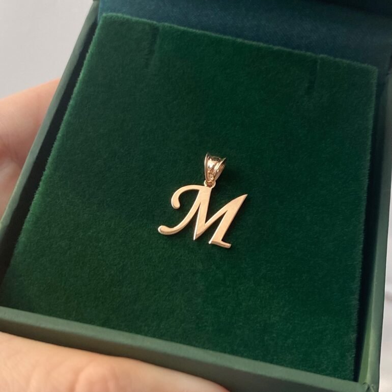 A 14ct rose gold pendant in a shape of initial M
