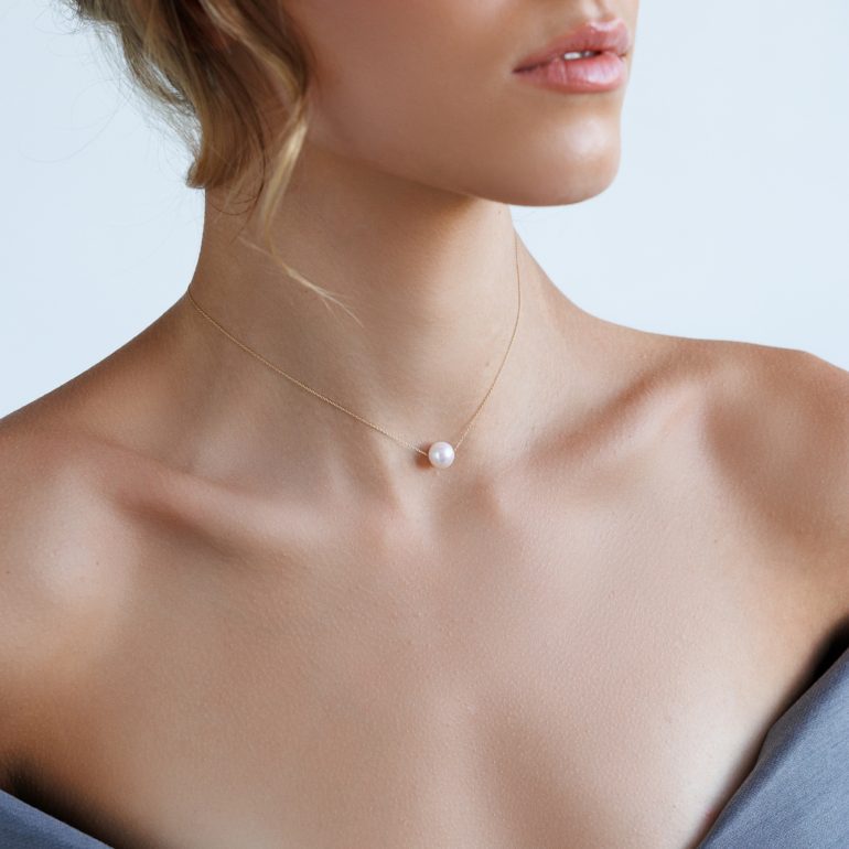 A minimalist rose gold necklace with white pearl