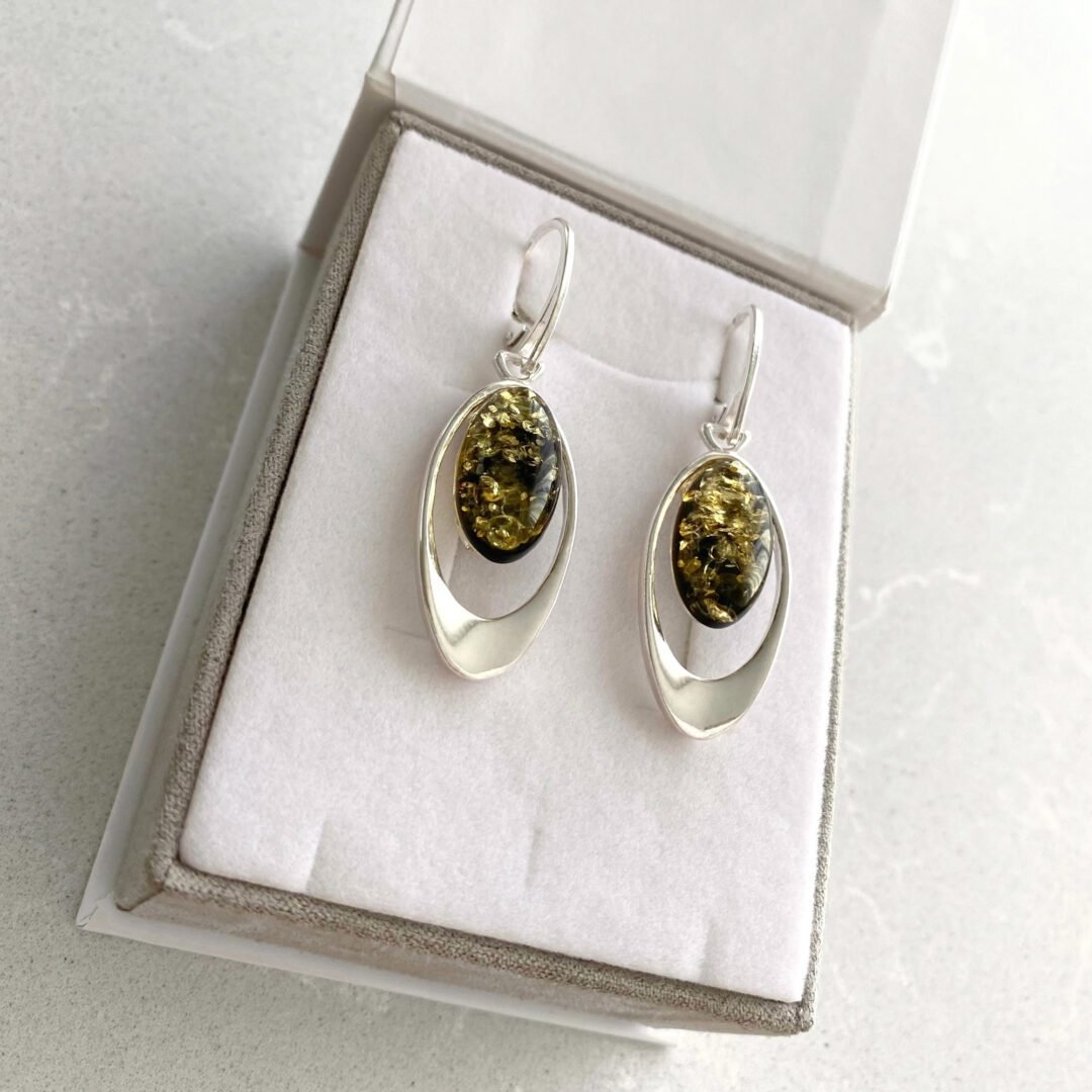 A pair of dandling sterling silver earrings with green amber