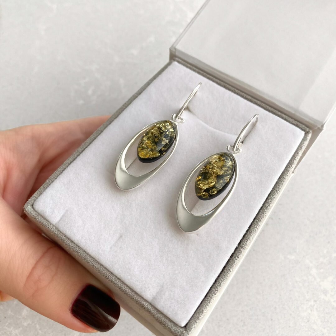 A pair of dandling sterling silver earrings with green amber